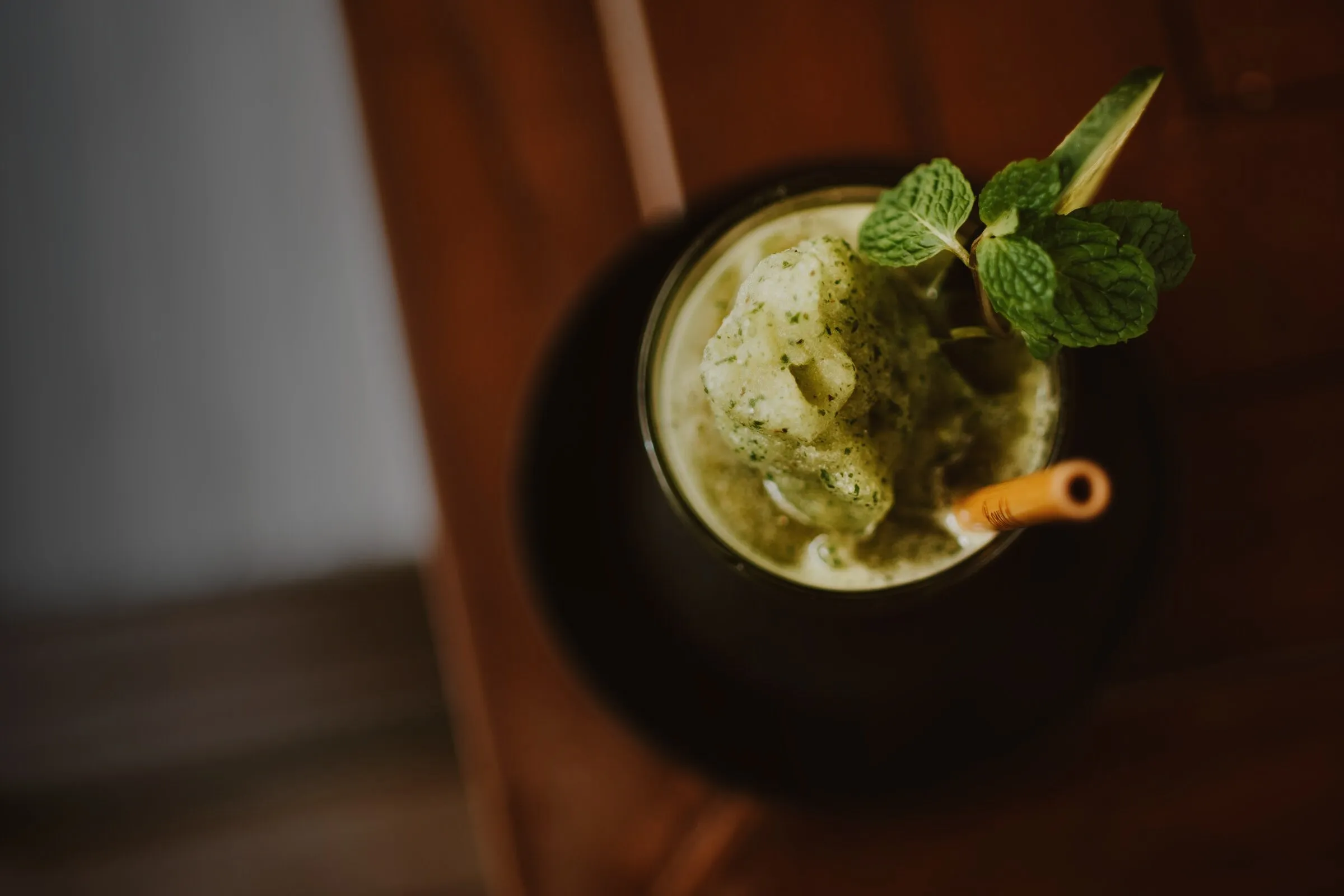 Glas mit grünem Smoothie und Minzblatt