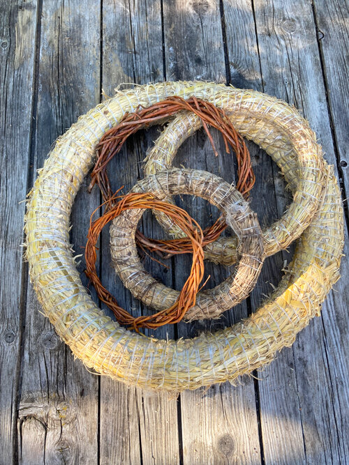 Kranzrohlinge aus Stroh und Weidenzweigen auf Holzbrettern